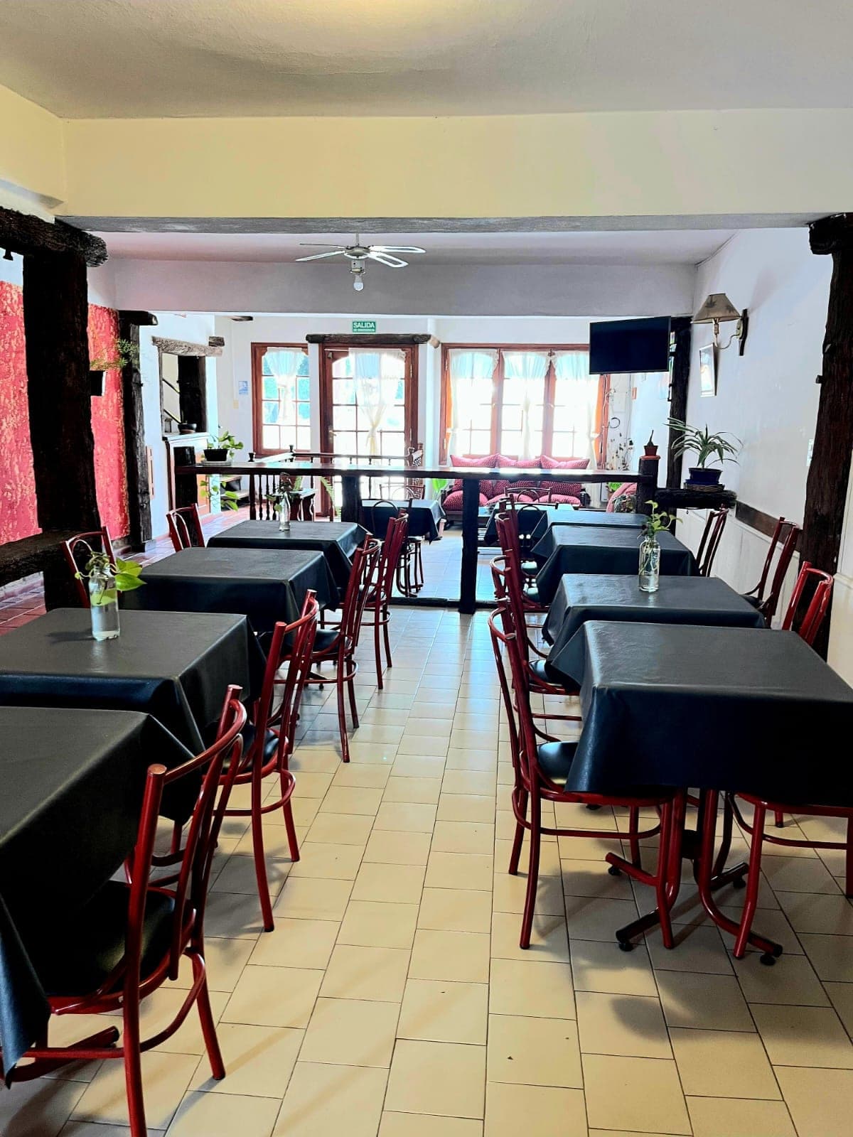 El comedor donde se sirve el desayuno, con mesas y sillas rojas