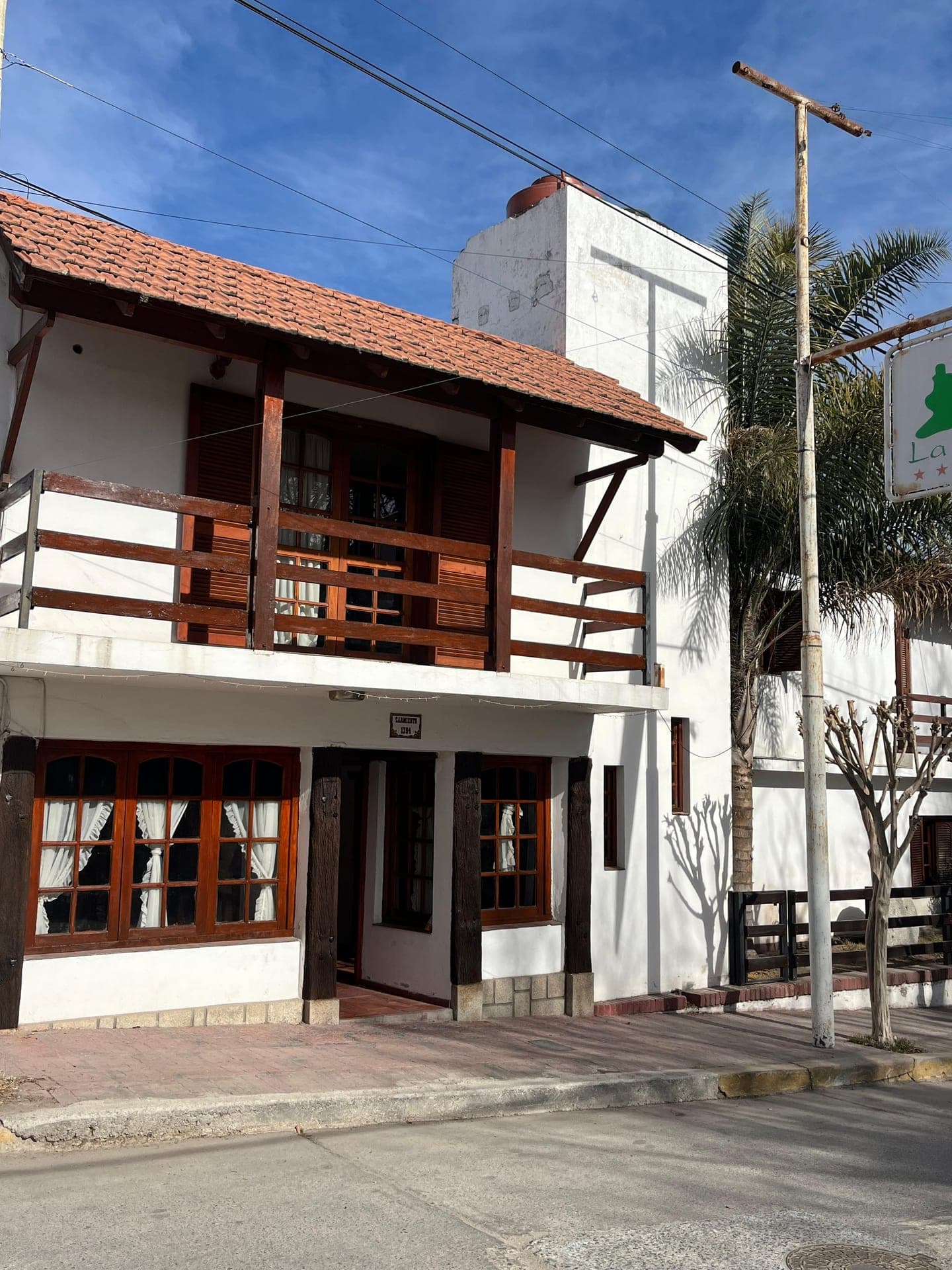 El frente de la Posada del Rey sobre la calle Sarmiento, con balcon de madera y techo de tejas